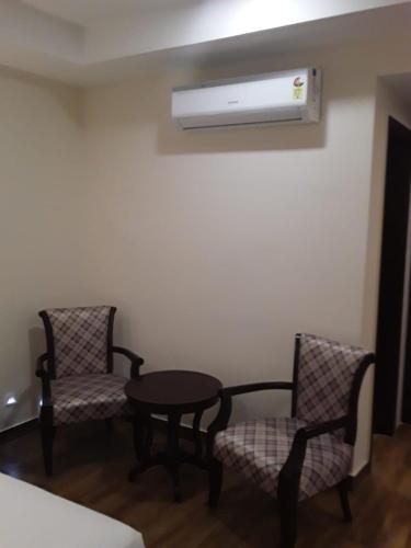 a room with two chairs and a table and a air conditioner at Aar Kay Inn & Suites in Jalandhar