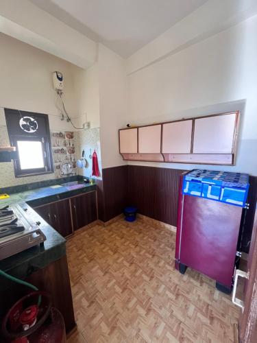 a kitchen with a refrigerator in the middle of a room at Residence Inn Homestay in Shimla