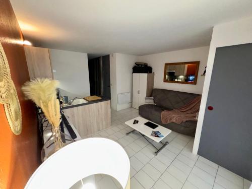 un petit salon avec un canapé et une table dans l'établissement Le Balcon Des Vagues, à Canet