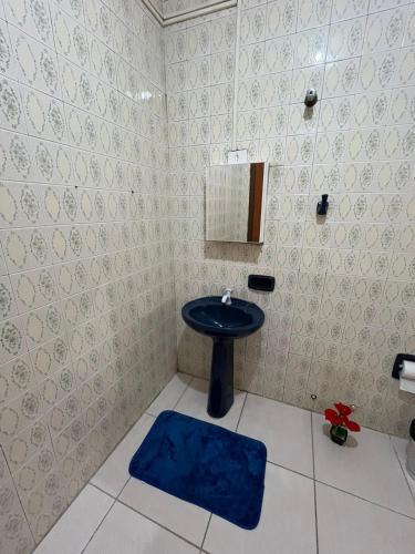a bathroom with a sink and a blue rug at Casa São Pedro in Aparecida