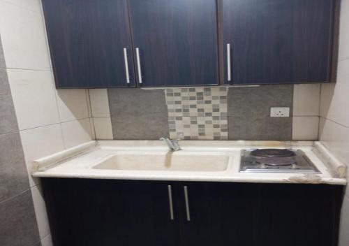 una cocina con fregadero y estufa en فندق أصالة الحمراء, en Yeda