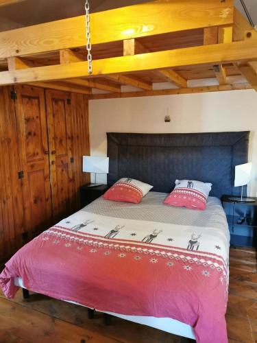 une chambre avec un grand lit avec des oreillers rouges et blancs dans l'établissement Gîte de l esqui, à Olette