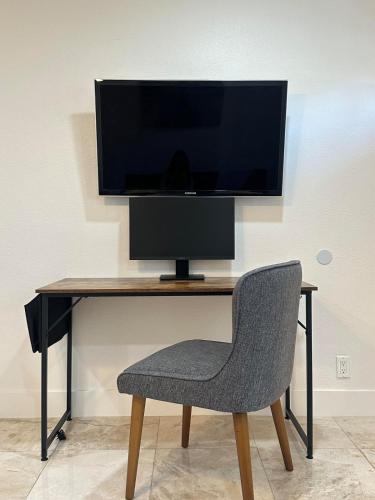 a desk with a computer monitor and a chair at Molivu Homes Studio - PetFriendly - King Bed - W-D in Los Gatos