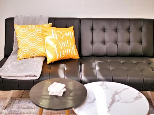 a leather couch with two pillows and a coffee table at Molivu Homes Studio - PetFriendly - King Bed - W-D in Los Gatos
