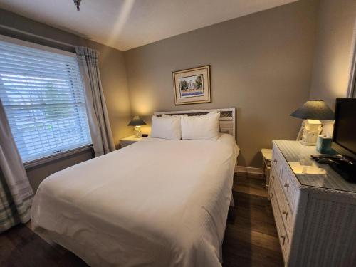 a bedroom with a large white bed and a window at North Shore Inn TC 204 in Traverse City