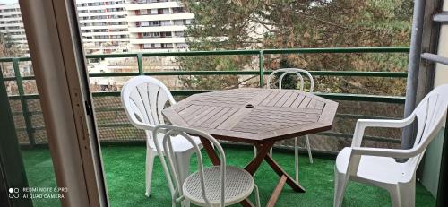 a wooden table and chairs on a balcony at Entre Ville & Nature-Sejour idéal a Massy in Massy
