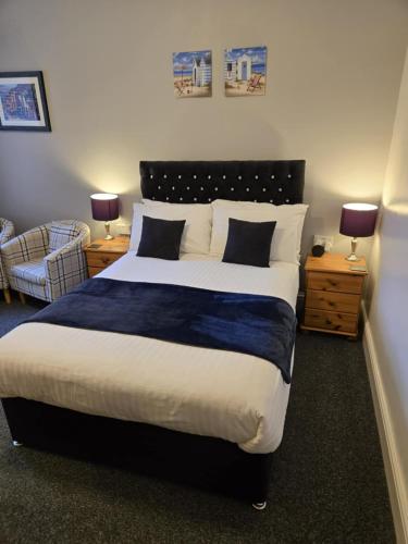 a bedroom with a large bed and two nightstands with lamps at Q Accommodation in Blackpool