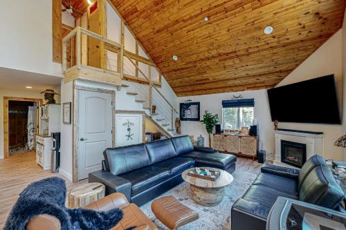 a living room with a black leather couch and a fireplace at Whispering Pines Retreat in Camp Connell