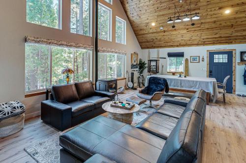 a living room with leather furniture and windows at Whispering Pines Retreat in Camp Connell