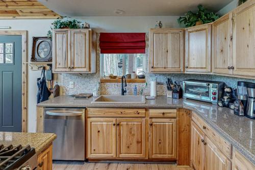 a kitchen with wooden cabinets and a sink at Whispering Pines Retreat in Camp Connell