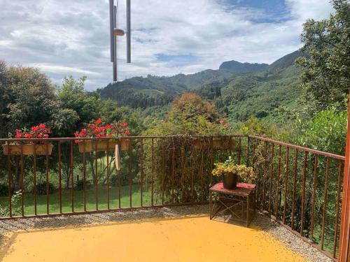 a balcony with a table and flowers on a fence at Casa de Campo en Tabio Cundinamarca in Tabio