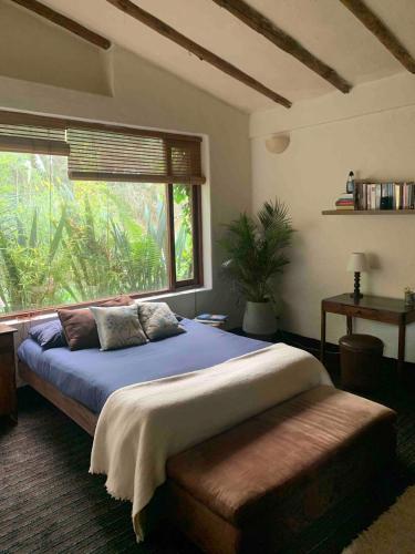 a bedroom with a large bed and a window at Casa de Campo en Tabio Cundinamarca in Tabio