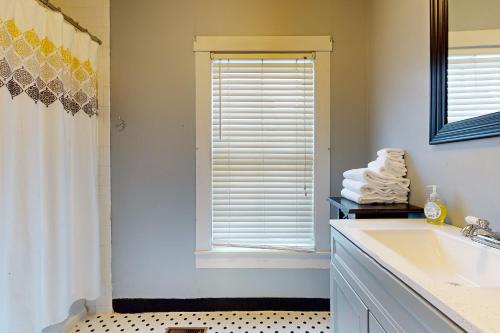 Green Door Cottage في Weston: حمام مع حوض ونافذة