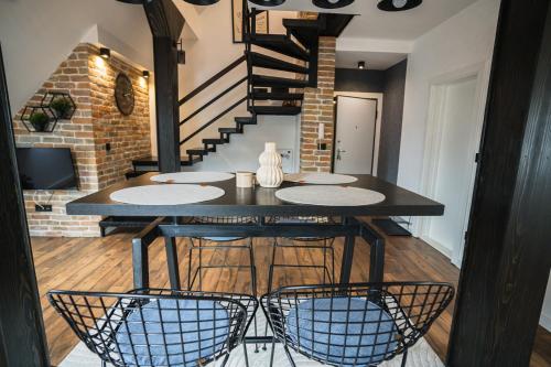 a dining room with a black table and chairs at Promenada Apartmani Zlatibor in Zlatibor