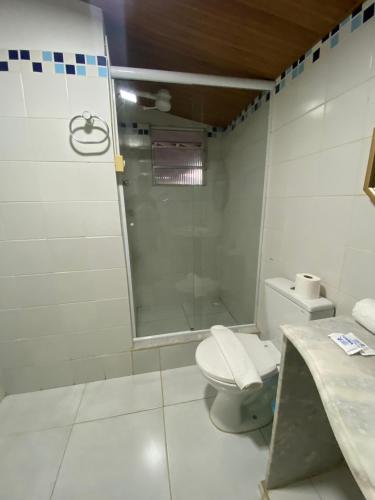 a bathroom with a shower and a toilet and a sink at Pousada Maracaju in Porto De Galinhas