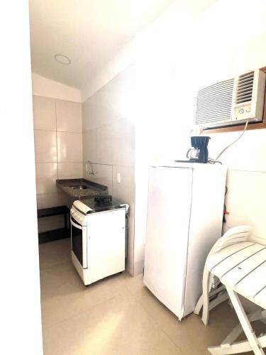 a small kitchen with a refrigerator and a stove at Pousada Praia do Recreio in Rio de Janeiro
