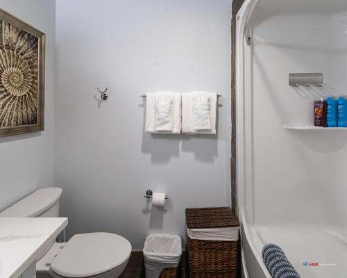 ein weißes Badezimmer mit Toilette und Dusche in der Unterkunft Solara Studio with Pool/Hot tub/Parking/Gym in Canmore