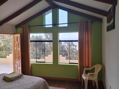 a bedroom with green walls and windows and a bed at Palacio del Inca Lodge in Comunidad Yumani