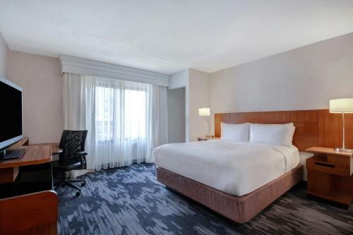 a hotel room with a bed and a desk and a television at Fairfield Inn and Suites by Marriott Rochester West/Greece in Rochester