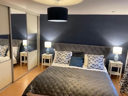 a bedroom with a large bed with two mirrors at Teach Biddy Rua Dungloe Townhouse in Dungloe