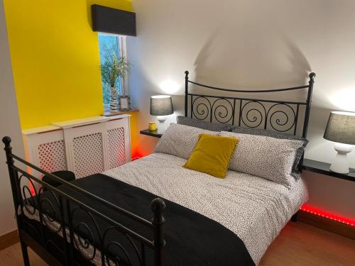 a bedroom with a black bed with a yellow pillow at Teach Biddy Rua Dungloe Townhouse in Dungloe