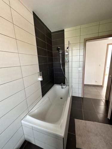 une salle de bain avec une baignoire blanche et une douche dans l'établissement Appartement comme une Maison, à Ingersheim