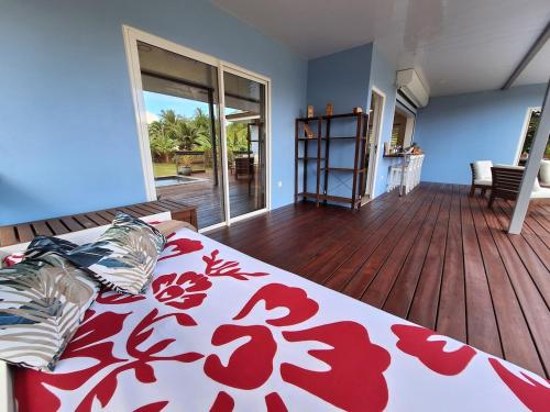a bedroom with a bed with a red and white blanket at FARE HEI - Maison 2 chambres avec Piscine privée et accès plage in Moorea