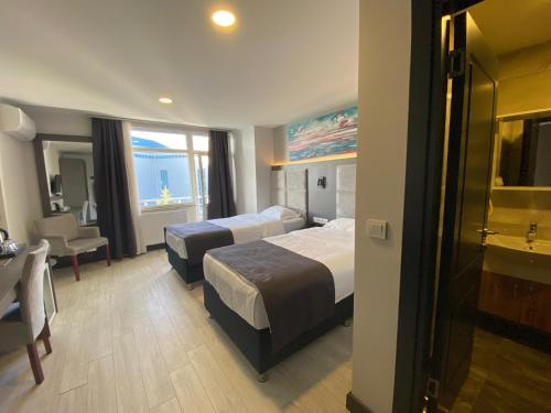トゥズラにあるSahil Hotel Pendikのベッド2台と机があるホテルの部屋
