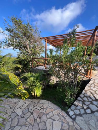 a wooden bench in a garden with plants at Pipa Golfinhos Pousada in Pipa