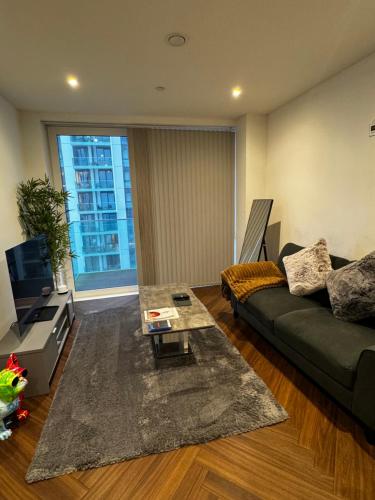 a living room with a couch and a table at Quartz manor in Manchester