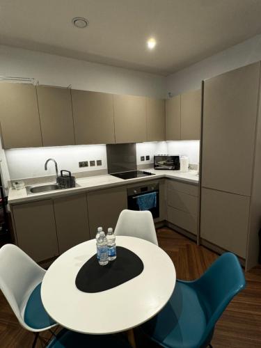 a small kitchen with a white table and chairs at Quartz manor in Manchester
