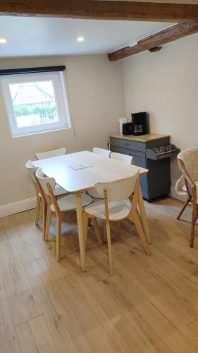 a white table and chairs in a room with a window at Gîte de l'étoile Achenheim 3 chambres - jacuzzi in Achenheim