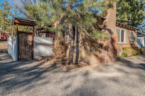 a house with a tree in front of a door at Enchanted Hideaway Cabins and Cottages in Ruidoso