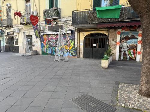 a street with graffiti on the side of a building at Stay In Naples - Arenaccia 211 Rooms and Suite in Naples