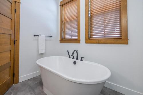 a white bath tub in a bathroom with windows at Suncadia 4 Bdrm Home with Hot Tub Overlooking Golf Course in Cle Elum