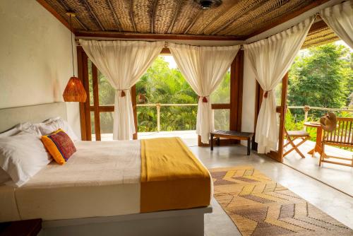 a bedroom with a bed and a large window at Finca Barlovento Maloka, Tayrona Park in Los Naranjos