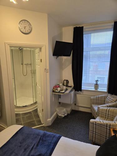 a hotel room with a shower and a bed at Q Accommodation in Blackpool