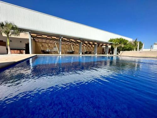 a large blue swimming pool in front of a building at Casa con casa club en la Paz BCS in La Paz