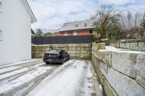 a black car parked on a snow covered street at Swiss Suites - Zofingen in Zofingen