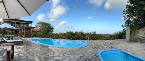 a swimming pool in a yard with a fence at Pipa Golfinhos Pousada in Pipa