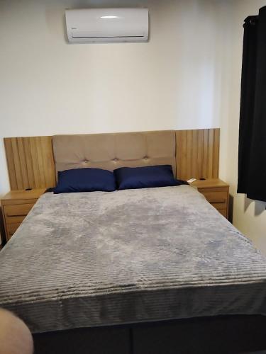 a bedroom with a bed with a blue pillow at Casa Próximo a shopping Catuaí in Foz do Iguaçu