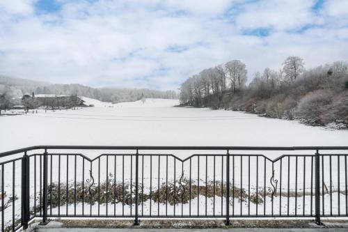 a view of a snow covered field behind a fence at Swiss Suites - Kollikerstrasse in Safenwil
