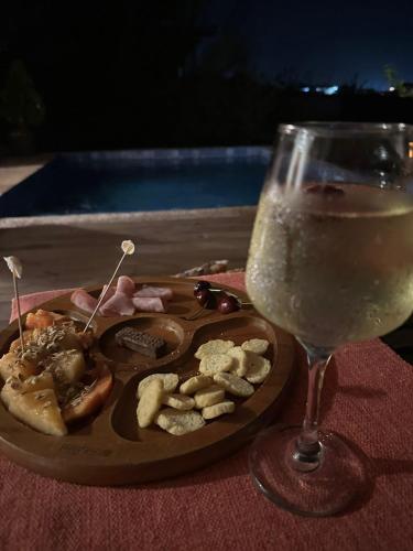 a plate of food next to a glass of wine at Bangalô Exclusivo Pontal do Maceió in Maceio