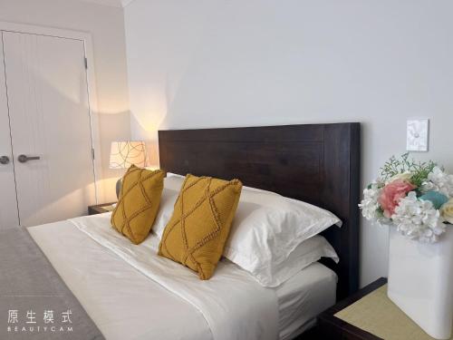 a bedroom with a bed with yellow pillows at Cozy sleepout in Hamilton