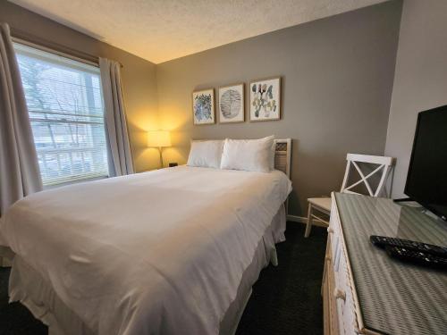 a bedroom with a large white bed and a window at North Shore Inn TC 205 in Traverse City