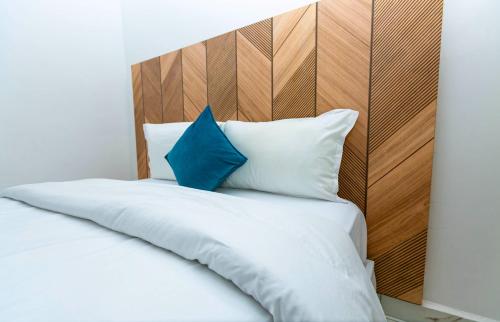 阿克拉Aster Luxury Apt close to Airport & Mall with Rooftop pool & gym的一张带白色床单和蓝色枕头的床