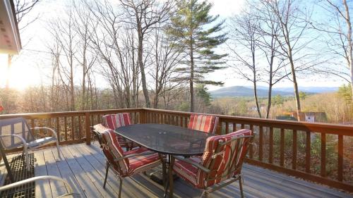 a table and chairs on a deck with a view at Rising Ridge 28, O in Campton
