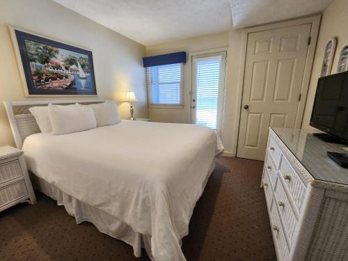 a bedroom with a large white bed and a television at North Shore Inn TC 106 in Traverse City