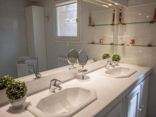 a bathroom with two sinks and two mirrors at La Sarrazine in Les Mées