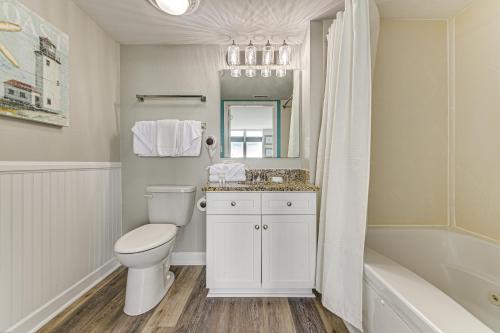 a bathroom with a toilet and a sink and a tub at Oceanfront North Myrtle Beach Gem Pools Access! in Myrtle Beach